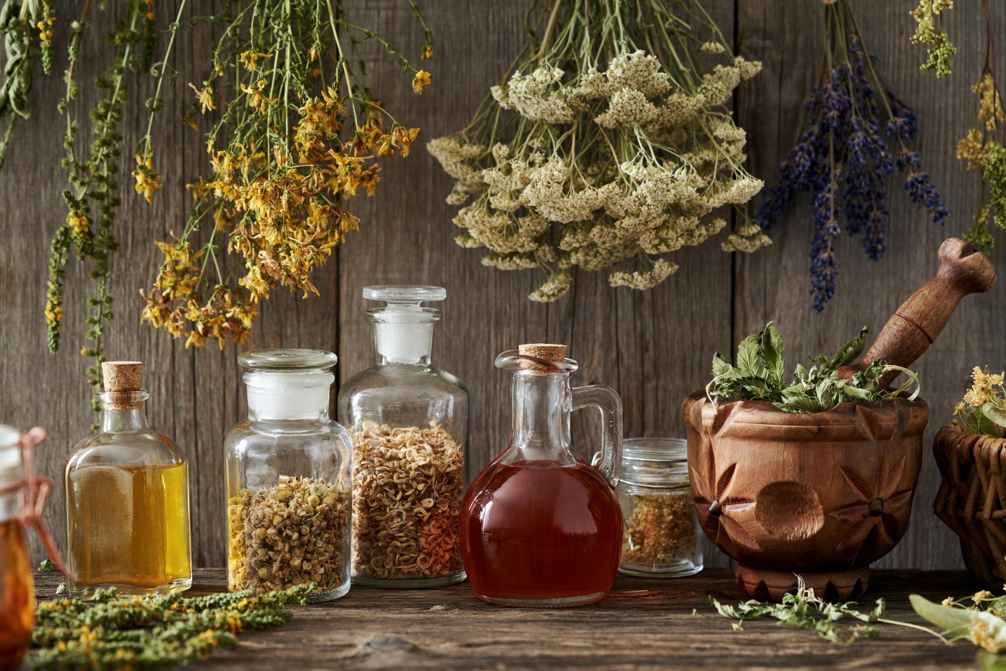 Glass apothecary bottles and jars with dried herbs and tinctures